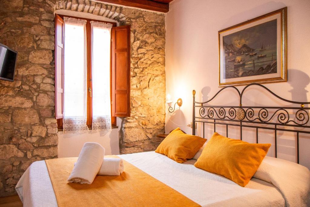 a bedroom with a bed in a stone wall at S’ammentu house in Bosa