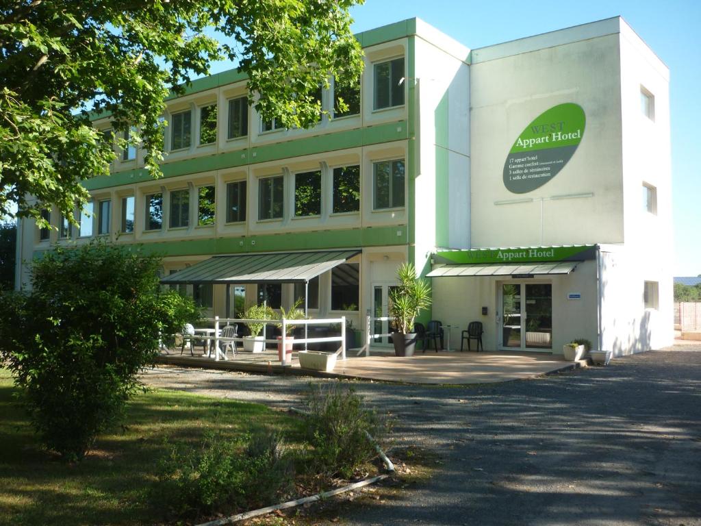 ein großes Gebäude mit einer Veranda davor in der Unterkunft West Appart' Hôtel in Bessines