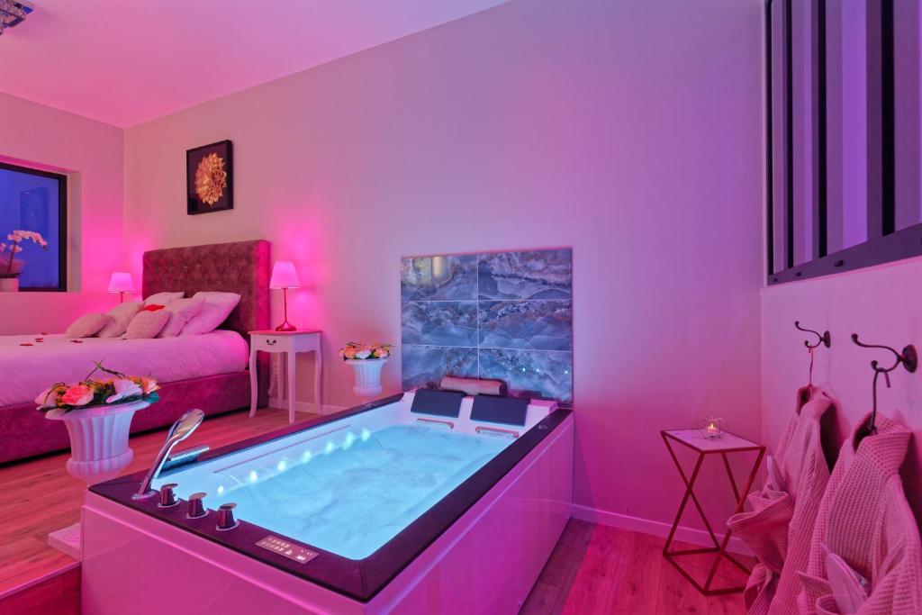 a living room with a hot tub in a pink room at Romance Spa Nuit D'amour in Le Havre