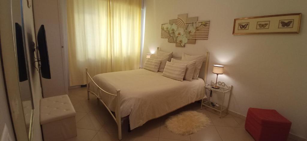 ein kleines Schlafzimmer mit einem Bett mit weißer Bettwäsche und Kissen in der Unterkunft La Buona Stella Apartment in Pistoia