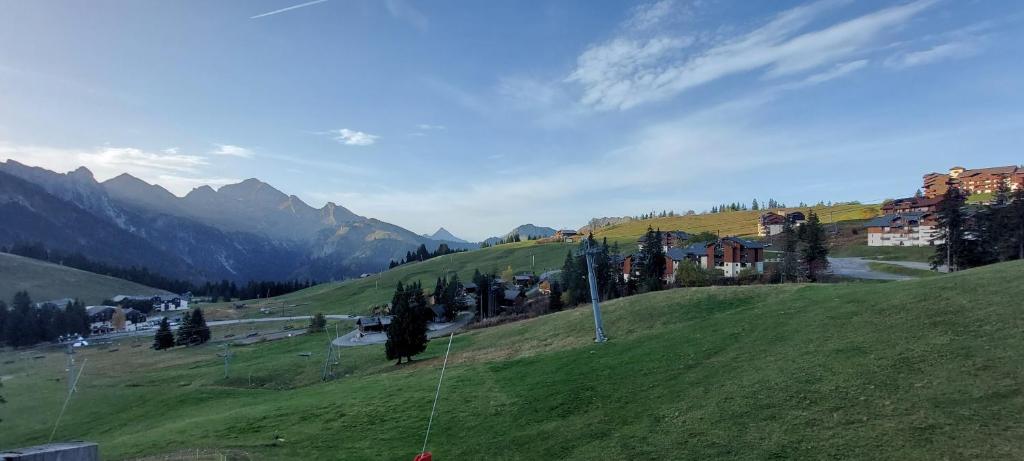 a green hillside with a town on top of it at Bal2502 in Manigod