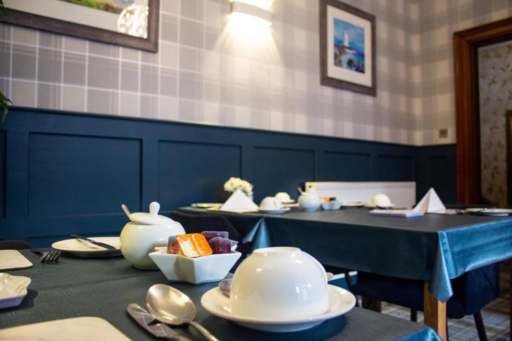 a dining room with a table with dishes on it at Kintrae B&B in Buckie