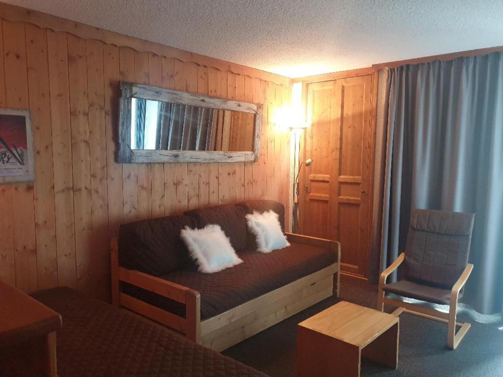 Cette petite chambre comprend un canapé et une chaise. dans l'établissement Charmant 2 pièces, centre, 5 pers. avec balcon, quartier La Croisette, Les Belleville - FR-1-574-9, aux Menuires