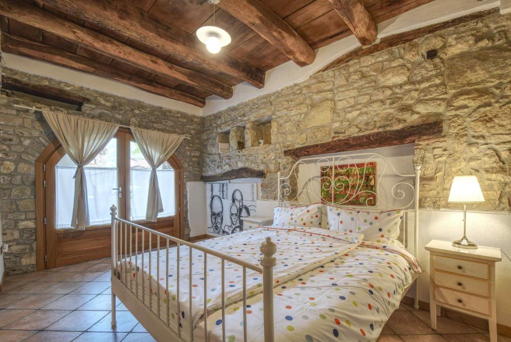 a bedroom with a bed in a stone wall at Romantic Boutique Hospitality in Revine Lago