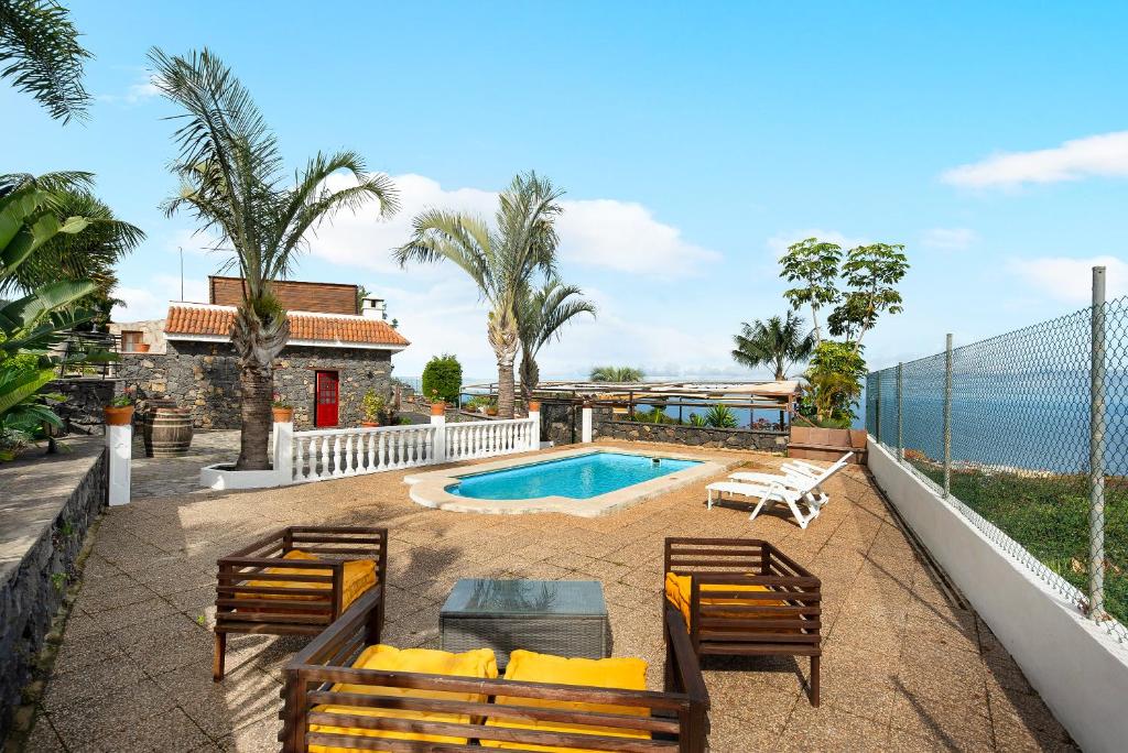 un cortile con piscina, sedie e una casa di Finca Viña Maria a Los Realejos