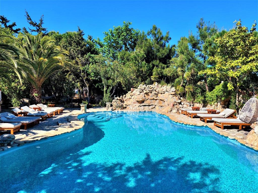 uma piscina com espreguiçadeiras e um resort em Kemerbag 29 Guest House 12 Yaş Üstü em Bozcaada