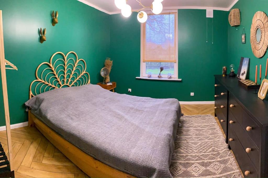 Wyszki的住宿－Domek z ogrzewaniem podłogowym，一间卧室设有一张床和绿色的墙壁