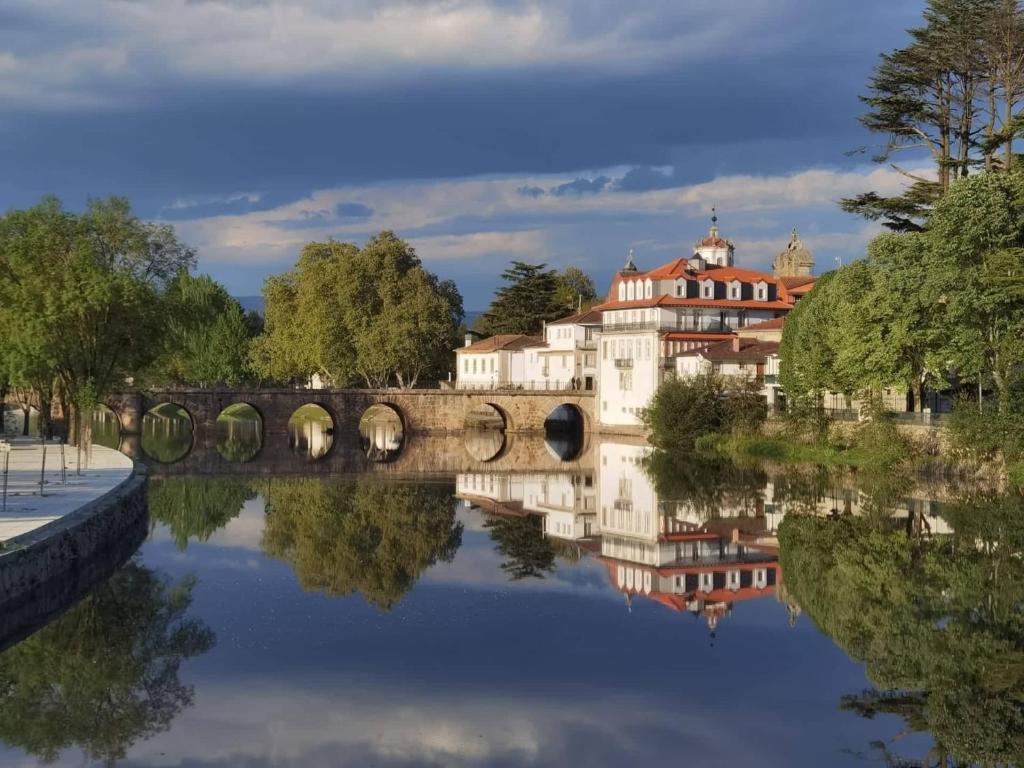 a bridge over a river with a building in the background at Casa Guardiao in Chaves