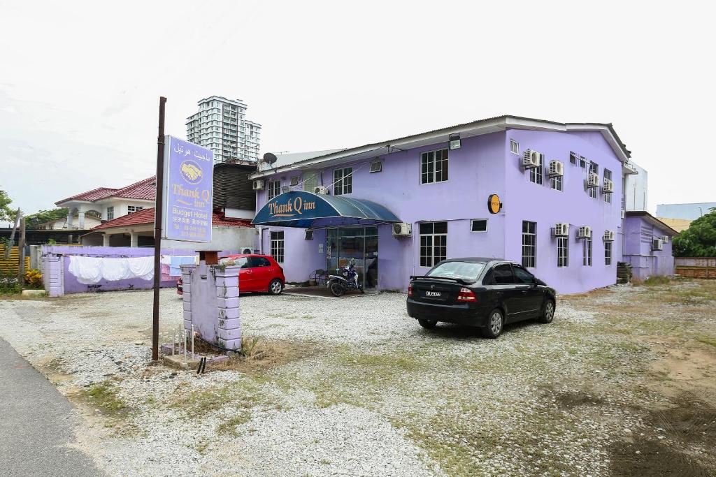 um carro estacionado em frente a um edifício roxo em OYO 89925 Innap Kota Bharu em Kota Bharu