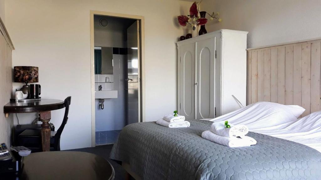 een slaapkamer met een bed met handdoeken erop bij bed and breakfast Simmerwille in Earnewâld