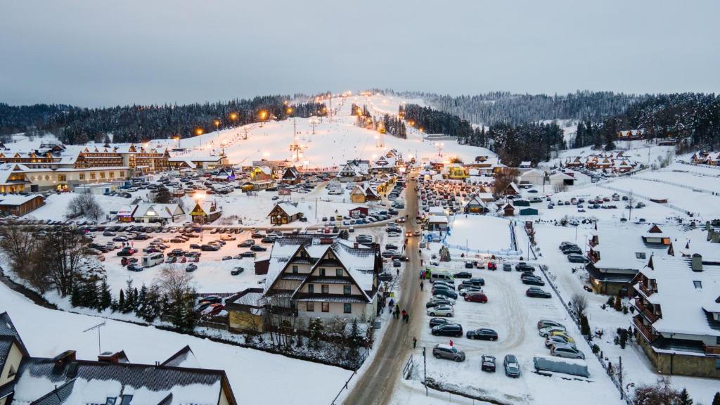 a town in the snow with cars parked at Willa Pod Kotelnicą in Białka Tatrzańska