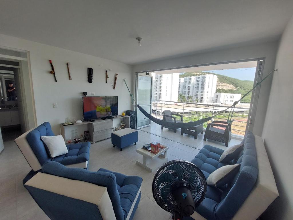 sala de estar con sofás azules y ventana grande en Apartamento Aqualina Orange Quinto Piso Vista a Montañas, en Girardot
