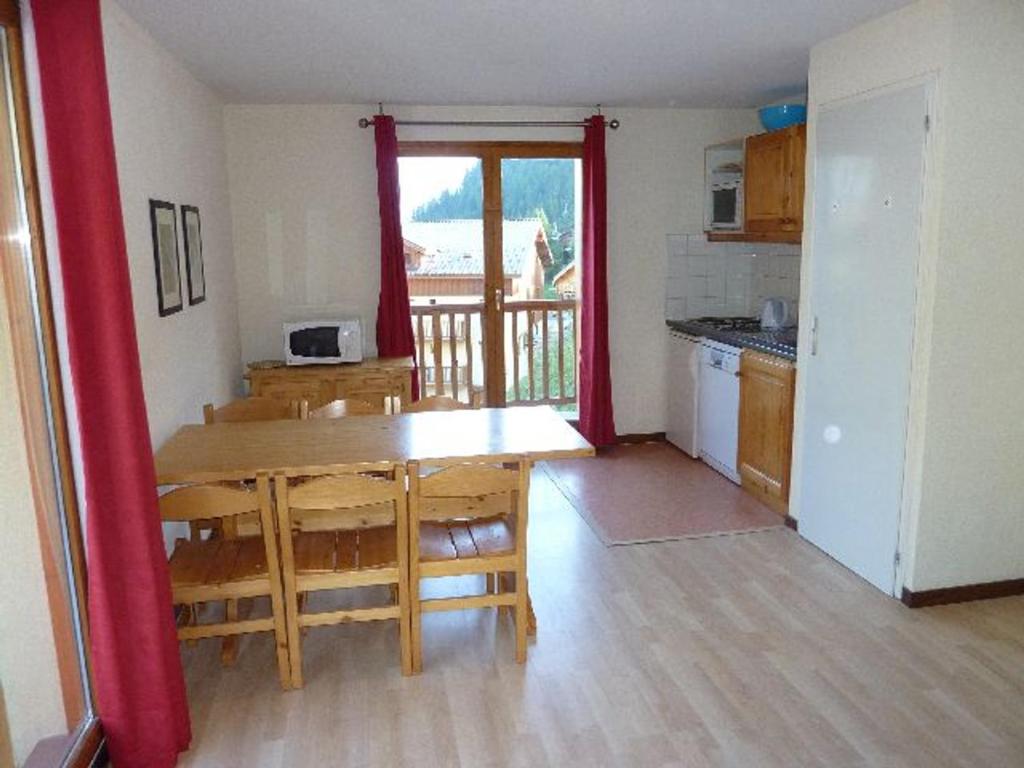 uma cozinha com uma mesa de madeira e uma sala de jantar com uma mesa em Appartement Valfréjus, 3 pièces, 6 personnes - FR-1-265-183 em Valfréjus
