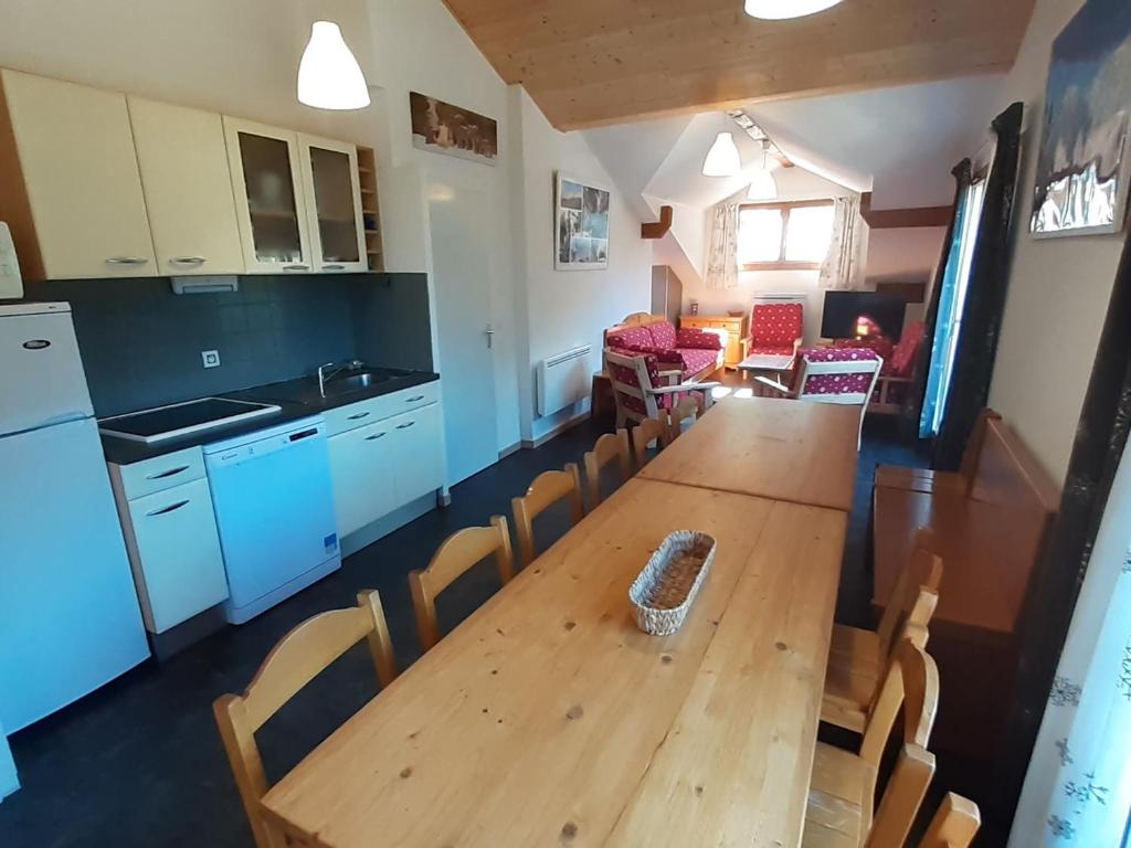 cocina y comedor con mesa de madera y sillas en Appartement Valfréjus, 5 pièces, 12 personnes - FR-1-265-180, en Valfréjus