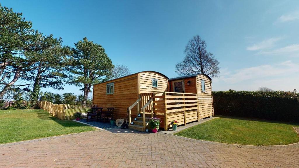 a tiny house sitting on top of a yard at Luxury Twin Shepherds Hut - Cosy & Romantic in Llandudno