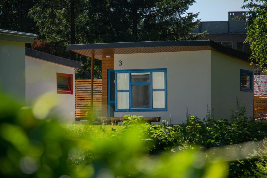 een klein huis met een blauw raam in een tuin bij Osada Chmielaki in Pokrzywna