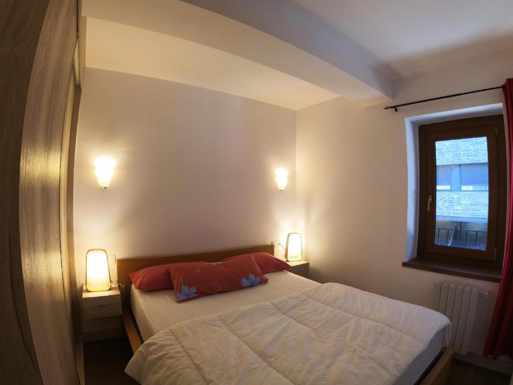 a small bedroom with a bed and two lamps at Soldeu Paradis Solneu in Soldeu