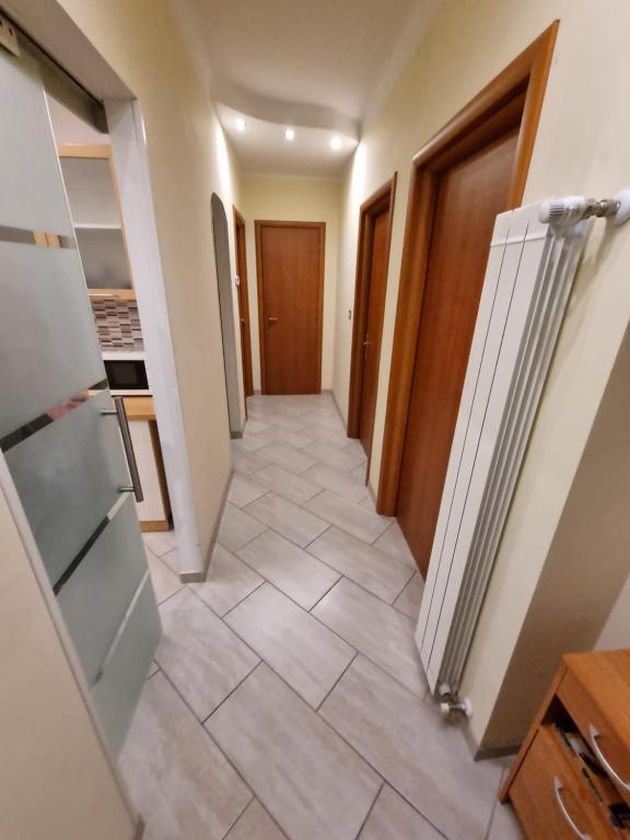 einen Flur, der in eine Küche mit Fliesenboden führt in der Unterkunft Appartamento Valentinis 74 in Monfalcone