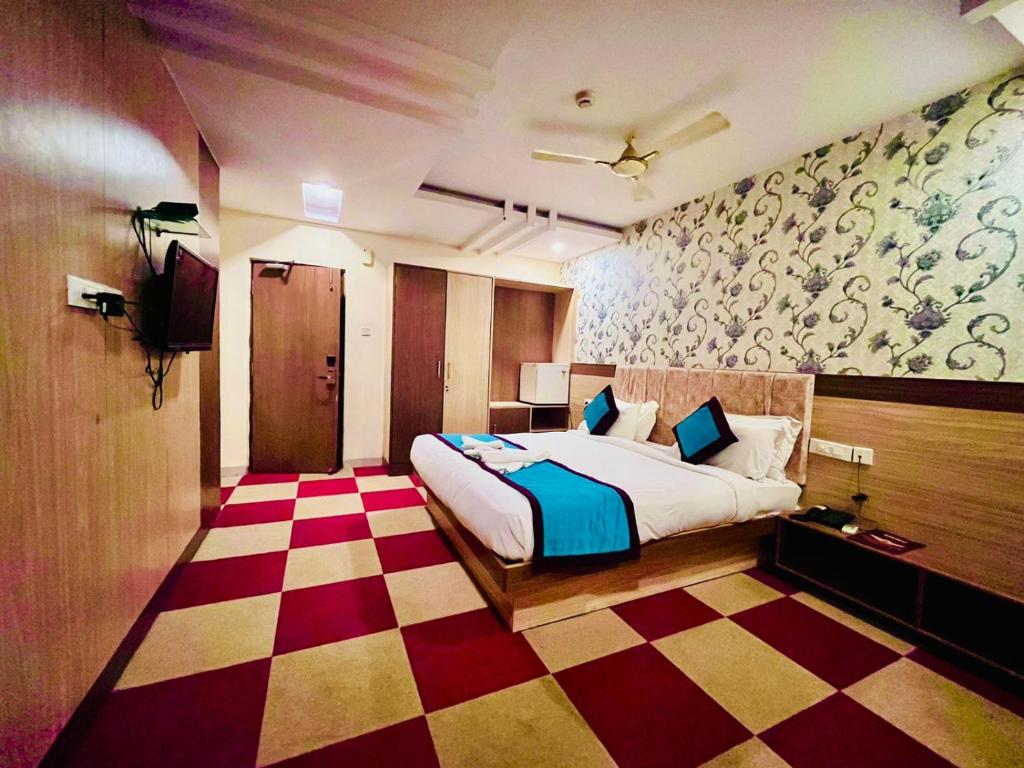 a bedroom with a bed and a checkered floor at HOTEL SM DECCAN PARK in Shamshabad