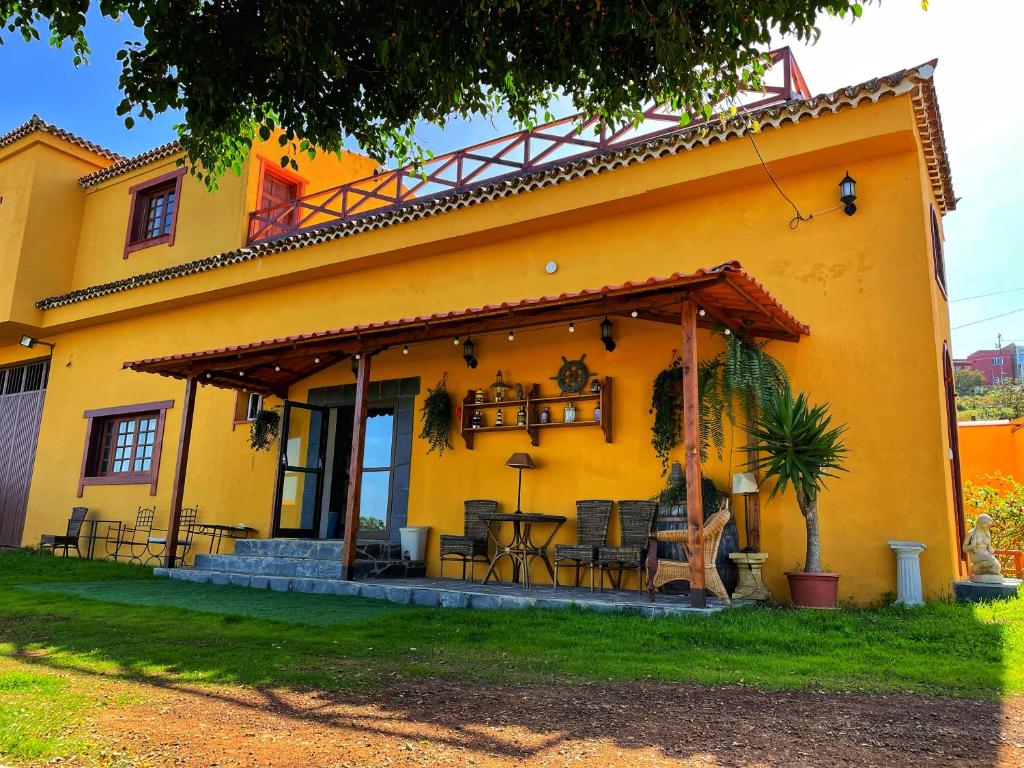 une maison jaune avec une terrasse en face de celle-ci dans l'établissement Villa Fort Tenerife, à Tacoronte