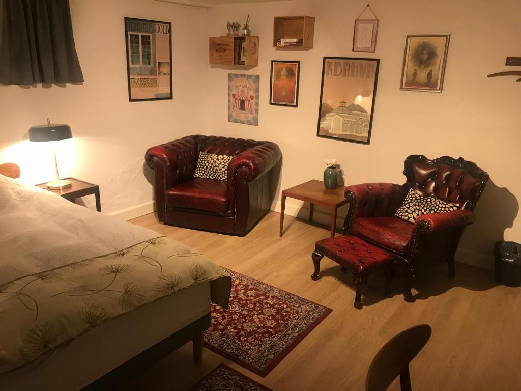 - une chambre avec deux chaises, un lit et une table dans l'établissement Comfortable Large Room King S bed near CPH centre, à Copenhague