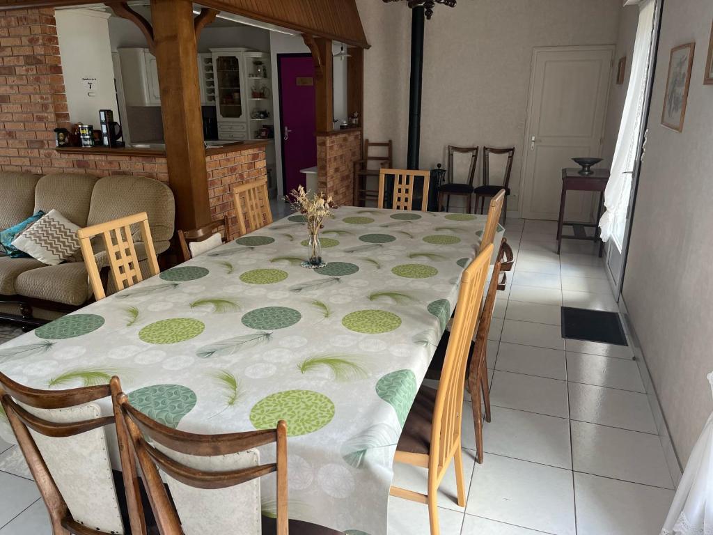 a dining room table with a white and green table cloth at Entre mûres et châtaignes in Les Châtelliers-Châteaumur