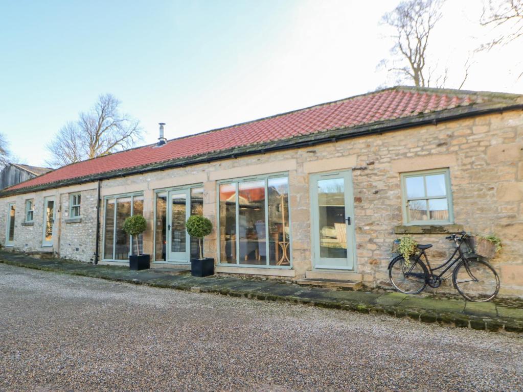 a building with a bike parked outside of it at The Cartshed, Sedbury Park Farm in Gilling