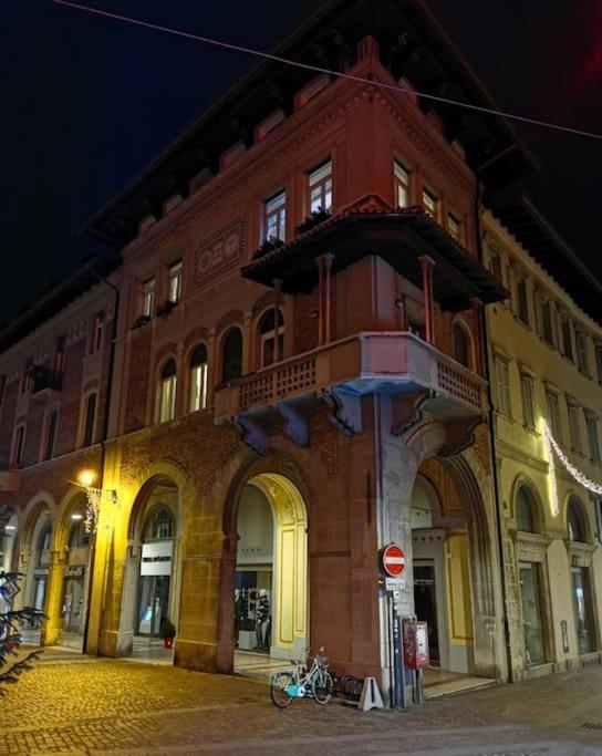 a large brick building on a street at night at Apartments via Roma in Rovereto