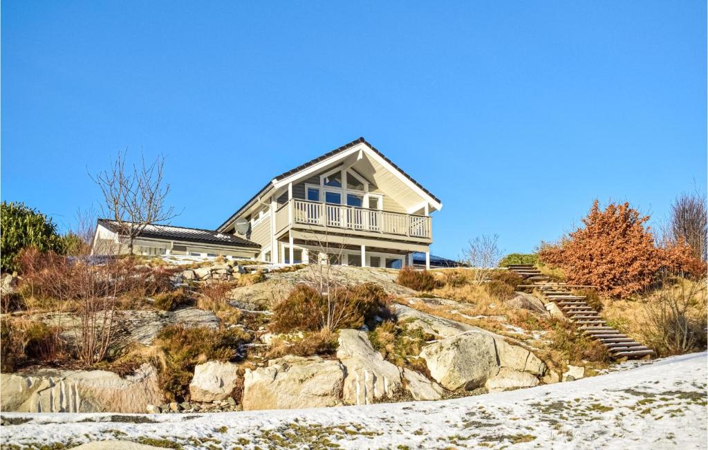 une maison au sommet d'une colline avec des rochers dans l'établissement 4 Bedroom Cozy Home In Fitjar, à Fitjar