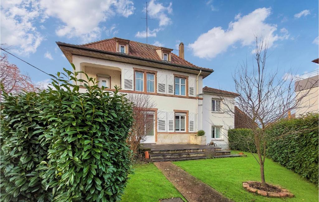 una gran casa blanca con un patio verde en 3 Bedroom Stunning Home In Erstein, en Erstein