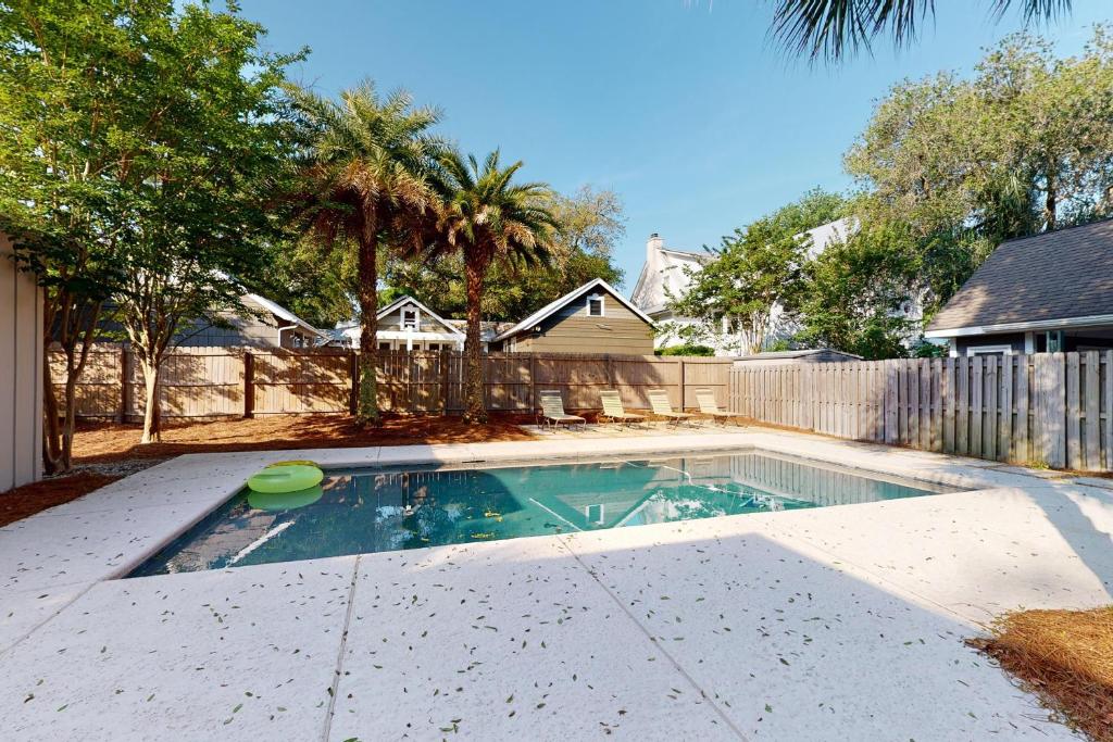a swimming pool with a frisbee in a yard at Latitude Adjustment - 4311 Ninth Street in Saint Simons Island