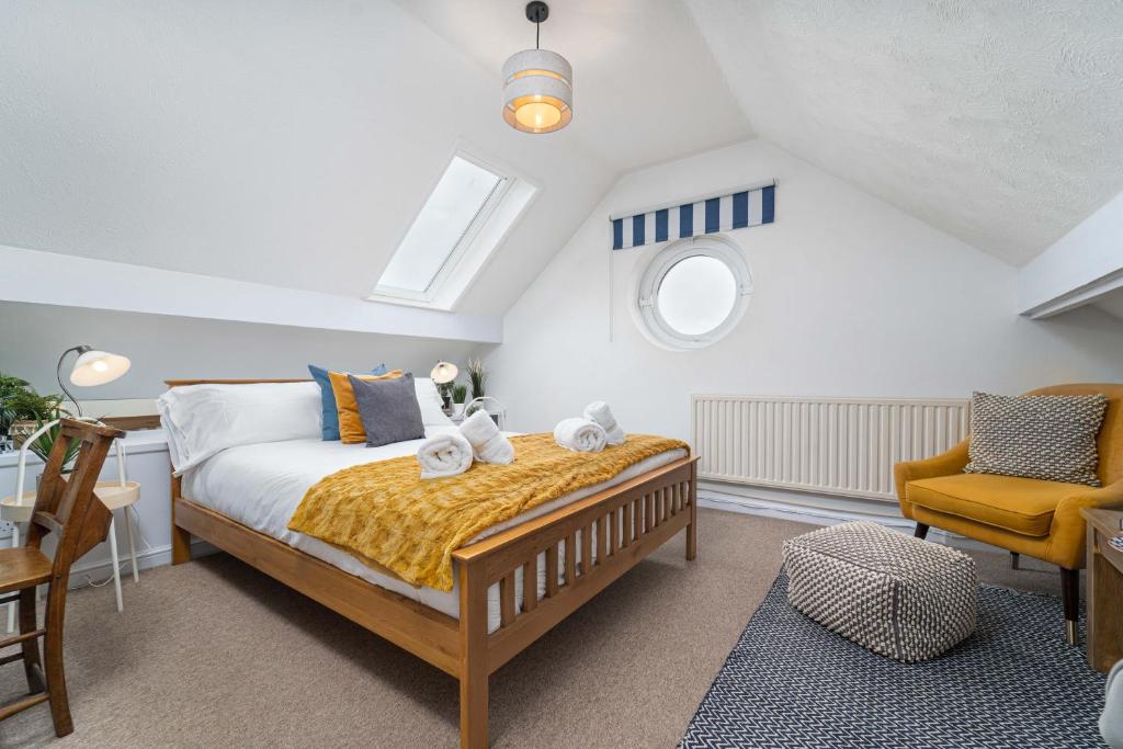 a bedroom with a bed and a chair and a window at Number One - Stones Court in St Ives