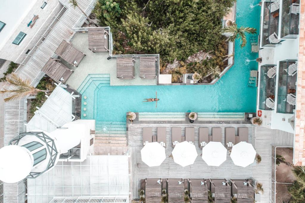 an overhead view of a pool with umbrellas at Naay Boutique Hotel Holbox in Holbox Island