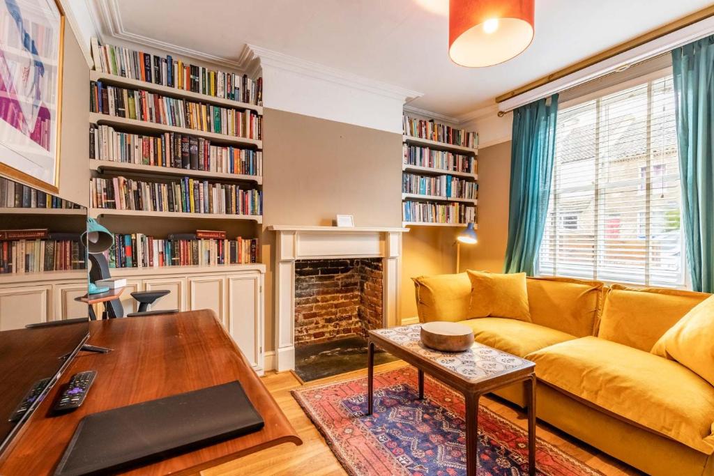 a living room with a yellow couch and a fireplace at Lindley Terrace - Norfolk Holiday Properties in Norwich