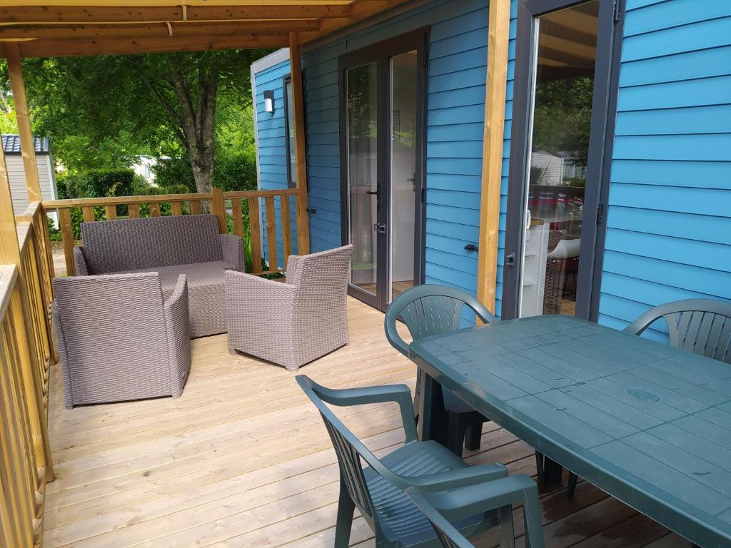 um deque com uma mesa e cadeiras numa casa em Mobile Home tout confort C13 Domaine de Lanniron em Quimper