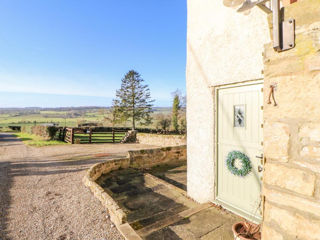 una puerta con una corona en el lateral de un edificio en The Stable, Sedbury Park Farm, en Gilling