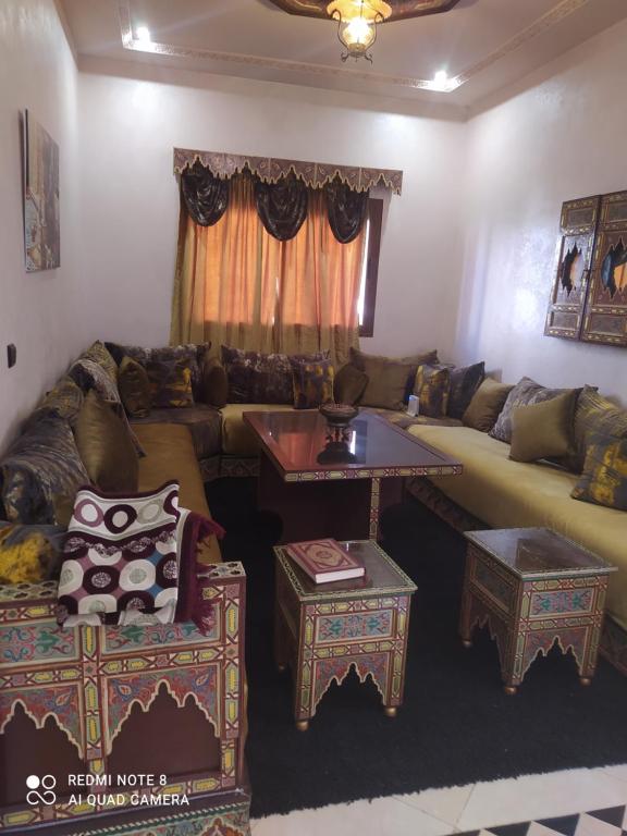 a living room with a couch and a table at Duplex pour famille seulement in Fez