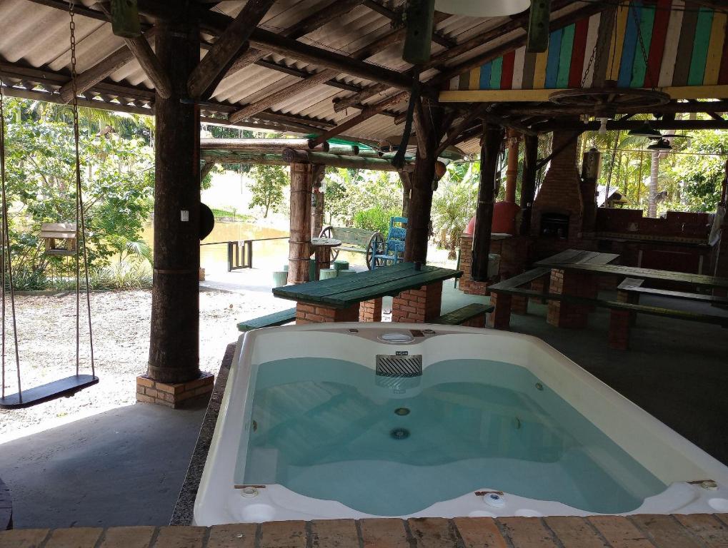 a jacuzzi tub in a building with a picnic table at Sitio Libardo em Meio a Natureza - Nova Trento in Nova Trento