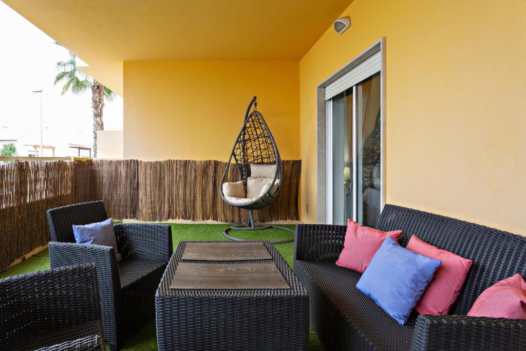 a patio with a couch and a table with pillows at Fleming Apartment in Tavira