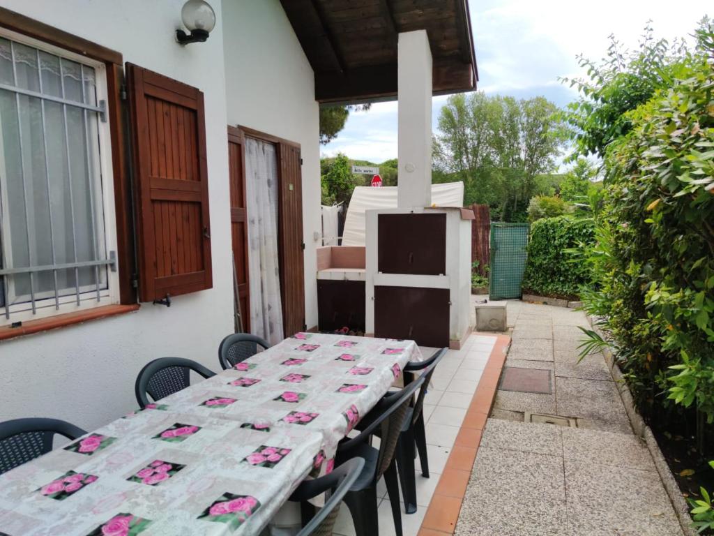 een tafel op een patio met roze bloemen erop bij Stellina in Lido di Volano