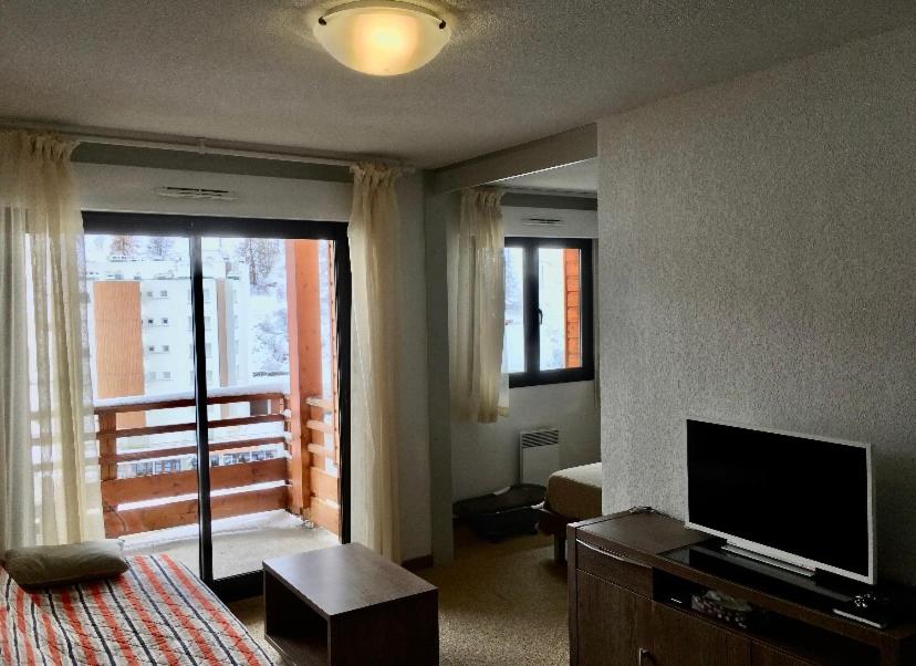 1 dormitorio con 1 cama, TV y ventana en Magnifique Appartement Valberg, en Péone