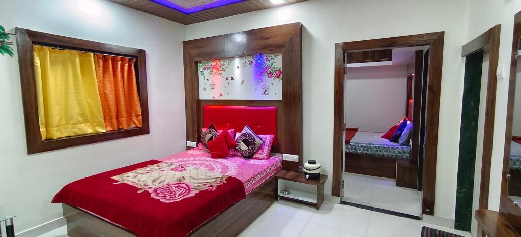 een slaapkamer met een rood bed en een spiegel bij Krishna Niwas in Mahabaleshwar
