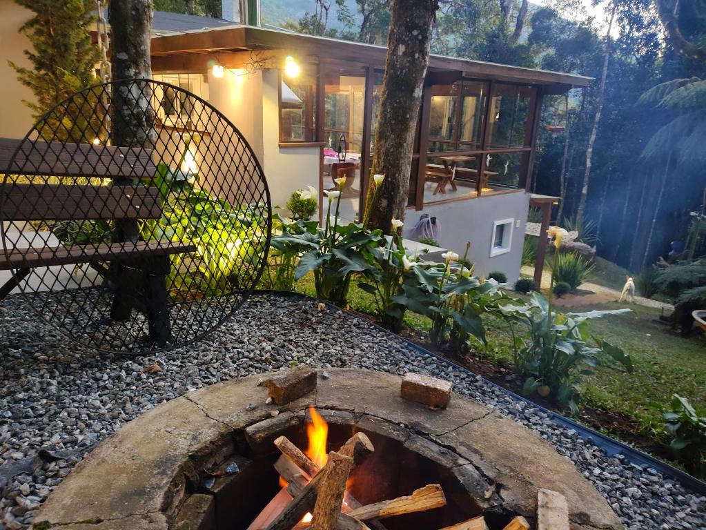 un foyer dans l'arrière-cour d'une maison dans l'établissement Refugio Familiar em Monte Verde, à Monte Verde