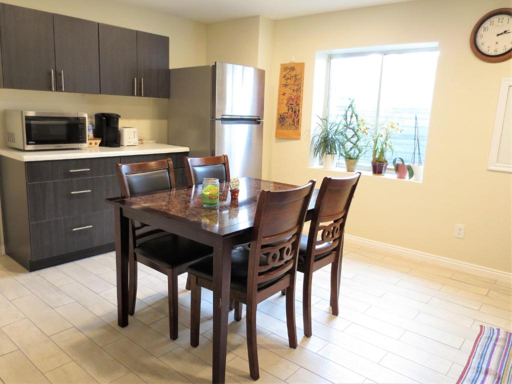 a kitchen with a table with chairs and a refrigerator at Entire Cozy Basement! Private Entrance! - Fast Wifi! in Salt Lake City