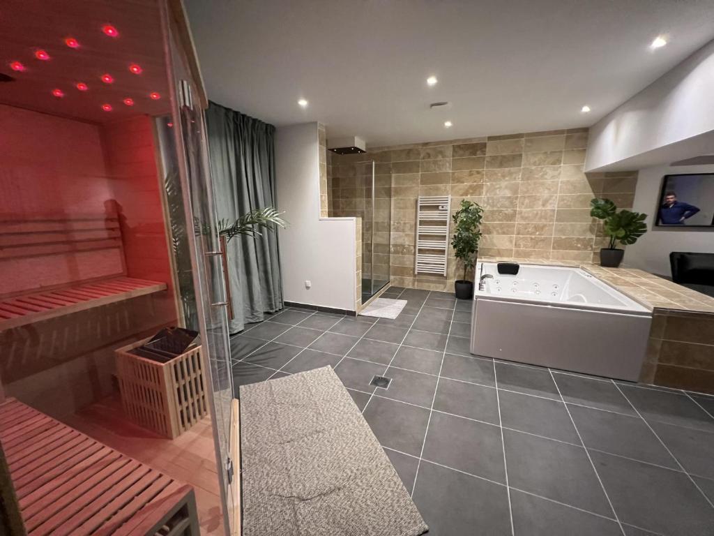 Habitación con baño grande con bañera. en Appart Spa Privatif Laon en Laon