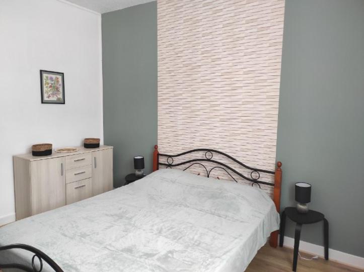 ein Schlafzimmer mit einem weißen Bett und einem Fenster in der Unterkunft Iris, Gîte Saint Antoine, Orcival, entre Sancy et Volcans d'Auvergne in Orcival