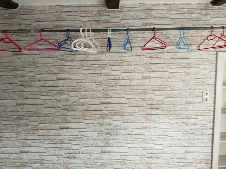 a brick wall with four hangers on a wall at Schönes Messe-Ferien Apartment mit vielen Extras in Bröckel