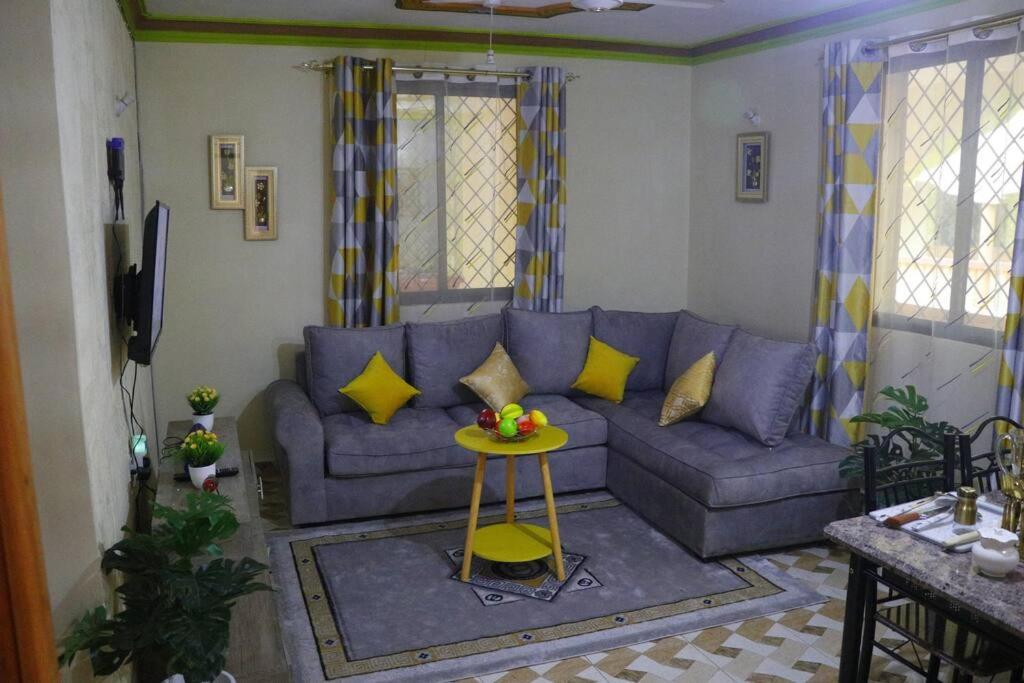 sala de estar con sofá azul y mesa en Stylish Cozy Home, en Mombasa