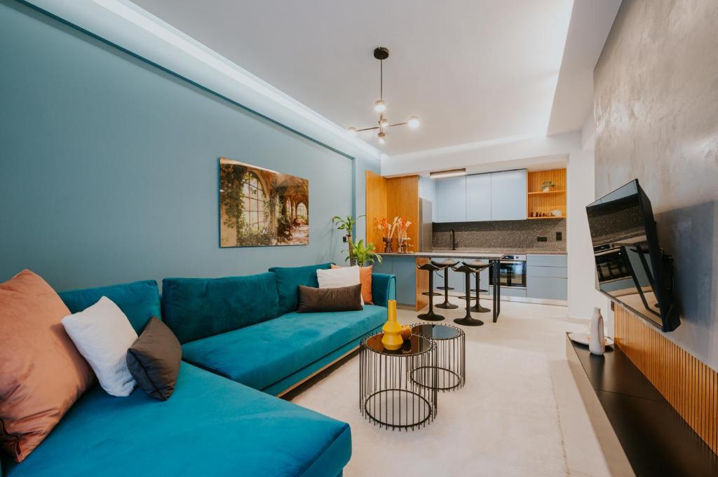 a living room with a blue couch and a kitchen at Azuro Luxury Living in Thessaloniki