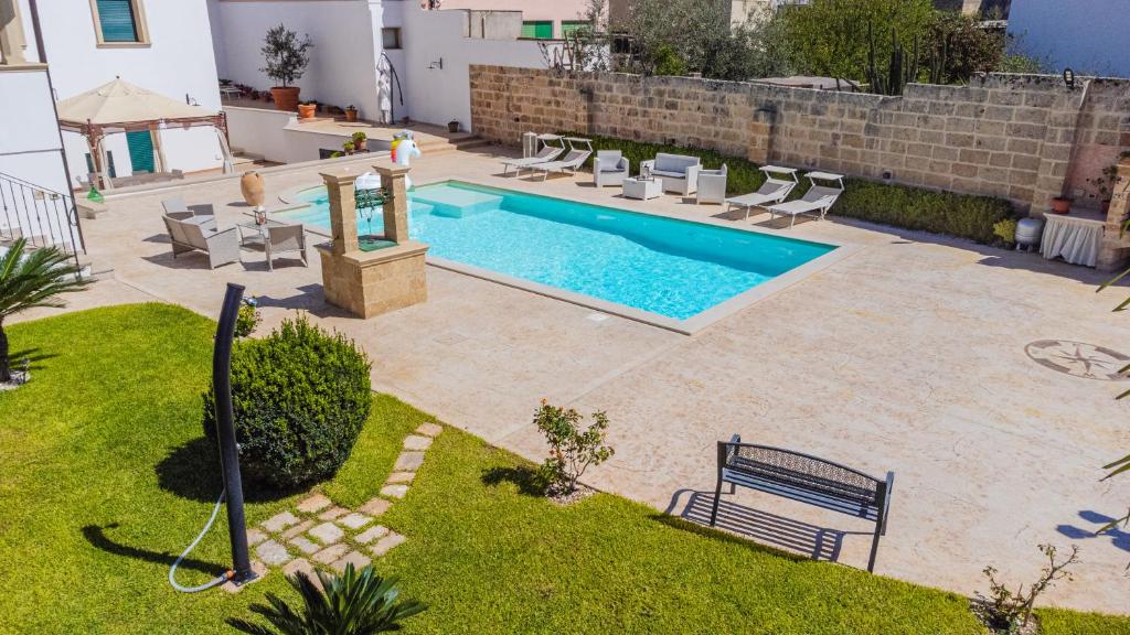 a swimming pool with chairs and a bench in a yard at Casa D'Amore con Piscina Privata in Alessano
